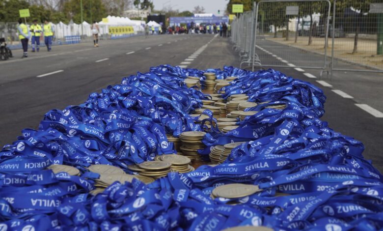 Stack of medals with blue ribbons at Sevilla Marathon, ready for winners' arrival.