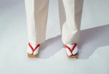 Close-up of traditional Japanese footwear and white socks on a light background.