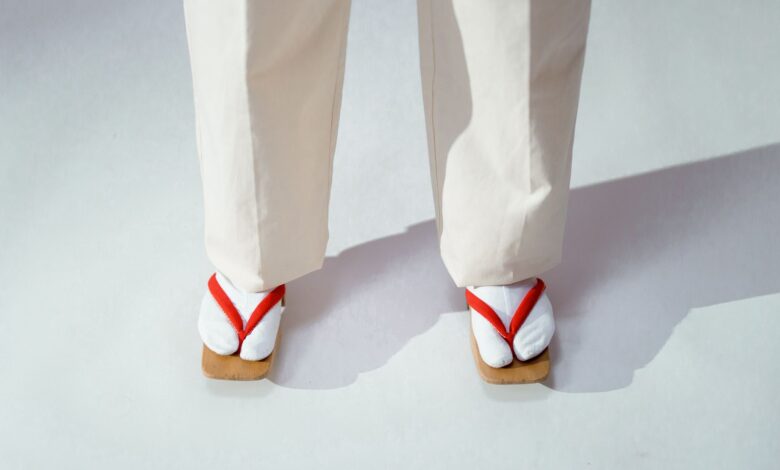Close-up of traditional Japanese footwear and white socks on a light background.