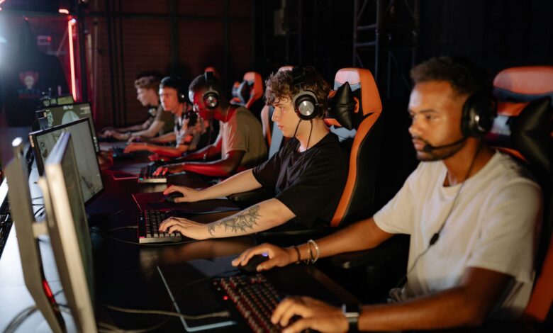 A group of focused young gamers playing in an intense esports tournament indoors.