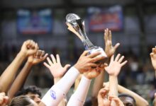 Group holds trophy in celebration, showcasing unity and achievement.