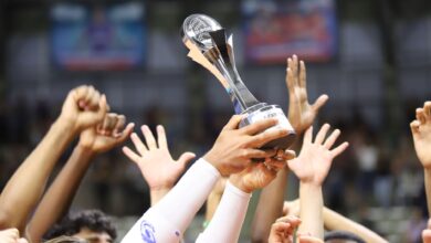 Group holds trophy in celebration, showcasing unity and achievement.