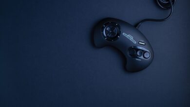 Navy blue vintage game console controller photographed from above on a dark background.