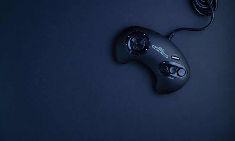 Navy blue vintage game console controller photographed from above on a dark background.