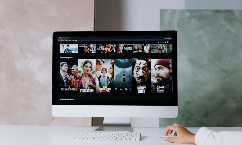 A modern workspace featuring a desktop screen displaying popular streaming series on Netflix.