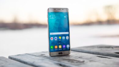 Samsung smartphone placed on a wooden surface outdoors during sunset.