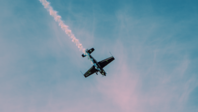 Dramatic stunt airplane showcasing aerobatics with a smoke trail against a clear sky.