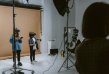 Two kids experience virtual reality gaming in a professional studio setting with VR headsets and controllers.