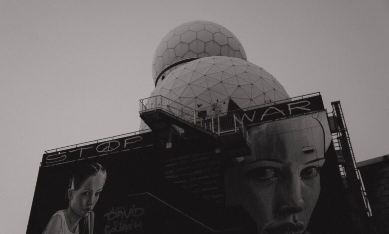 Black and white photo of anti-war mural on Teufelsberg Listening Station in Berlin, emphasizing peace.