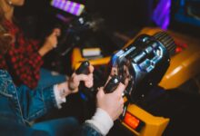 People enjoying a thrilling virtual reality driving simulation in a vibrant arcade setting.