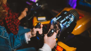 People enjoying a thrilling virtual reality driving simulation in a vibrant arcade setting.