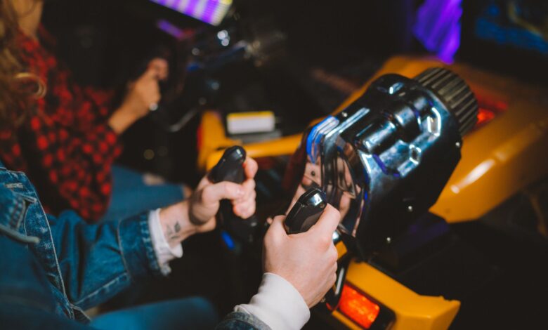 People enjoying a thrilling virtual reality driving simulation in a vibrant arcade setting.