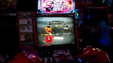 Close-up of an arcade gaming machine screen in a lively amusement center, offering speed racing game options.