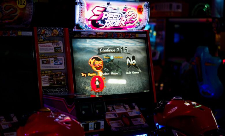 Close-up of an arcade gaming machine screen in a lively amusement center, offering speed racing game options.