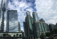 A stunning view of Toronto's modern skyline reflecting the iconic CN Tower on a bright day.