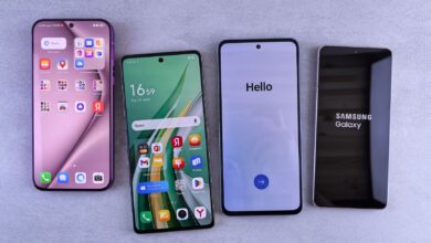Four modern smartphones showcasing home screens, applications, and startup logos on a sleek surface.