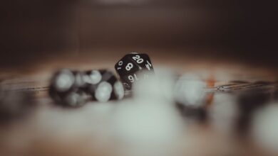 Artistic photo of multi-sided gaming dice in a blurred setting, highlighting the number 20.