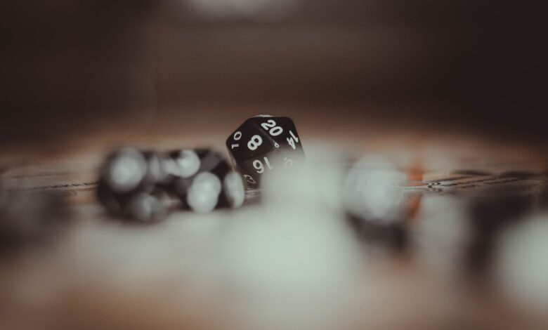 Artistic photo of multi-sided gaming dice in a blurred setting, highlighting the number 20.