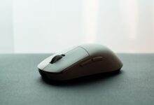 Close-up of a white wireless computer mouse on a dark surface, emphasizing sleek design.