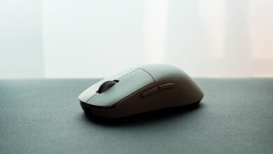Close-up of a white wireless computer mouse on a dark surface, emphasizing sleek design.