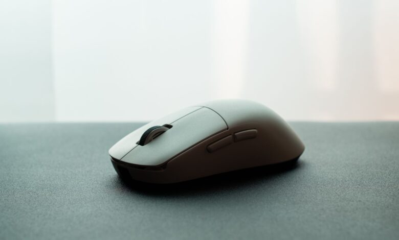 Close-up of a white wireless computer mouse on a dark surface, emphasizing sleek design.