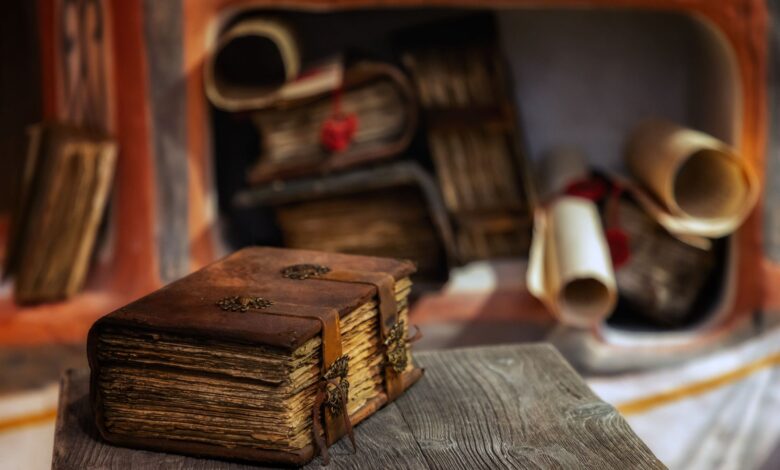 Close-up of a leather-bound antique book on a wooden table, with scrolls in the background, Moscow.