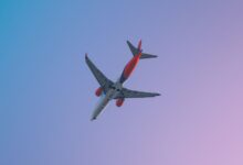 A Boeing 737 Max 8 airplane in flight against a clear sky during daytime in Pune, India.
