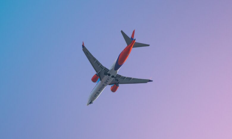 A Boeing 737 Max 8 airplane in flight against a clear sky during daytime in Pune, India.