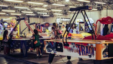 Children and adults enjoy air hockey games in a lively indoor arcade setting.
