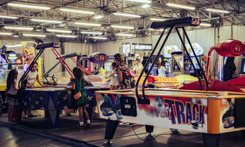 Children and adults enjoy air hockey games in a lively indoor arcade setting.