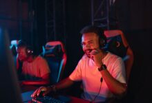 Two gamers immersed in an esports tournament, focused with headsets and keyboards.