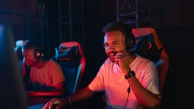 Two gamers immersed in an esports tournament, focused with headsets and keyboards.