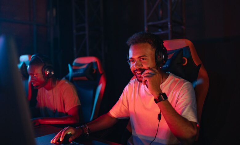 Two gamers immersed in an esports tournament, focused with headsets and keyboards.
