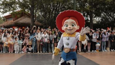 A vibrant Toy Story character parade at Shanghai Disneyland, featuring enthusiastic crowds and lively atmosphere.