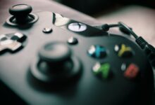 Detailed view of a black gaming controller showcasing its sleek design and colorful buttons.