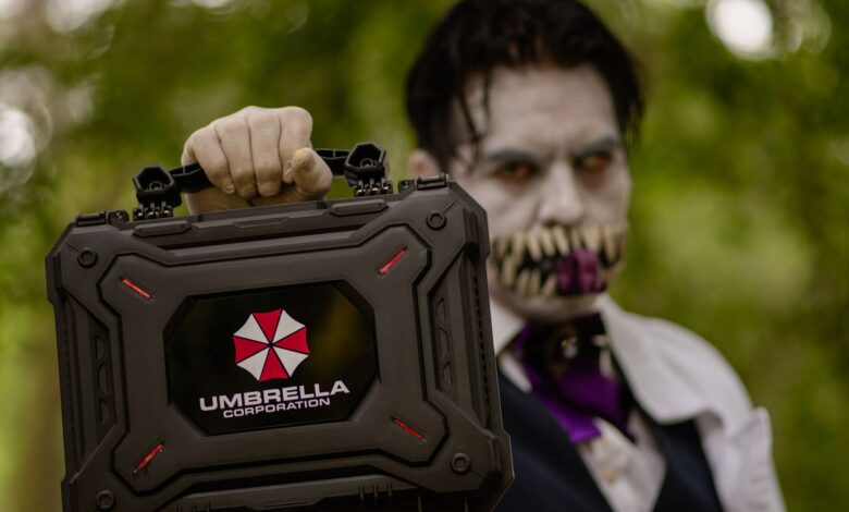 A cosplayer holding an Umbrella Corporation case, inspired by Resident Evil, ready for Halloween.