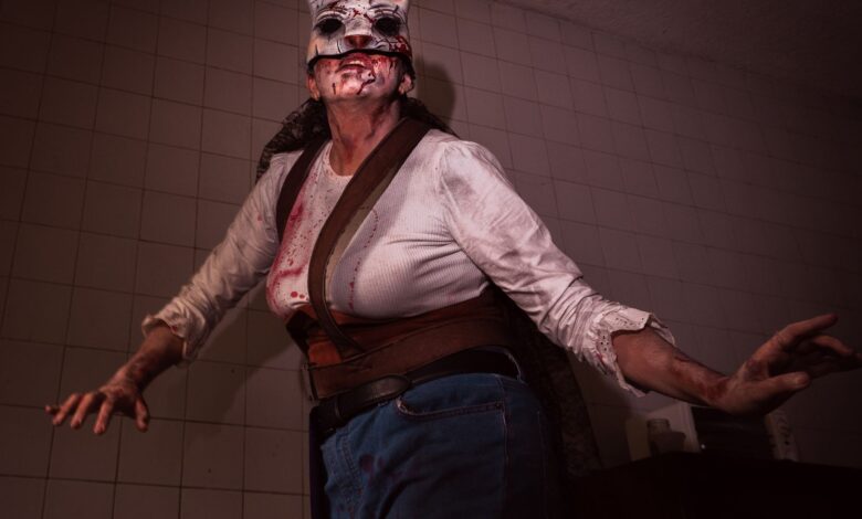 A person in a bloody rabbit mask costume poses ominously indoors, perfect for Halloween or horror themes.