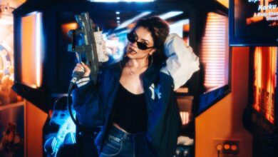 Fashionable young woman in an arcade holding a toy gun enjoying leisure time.