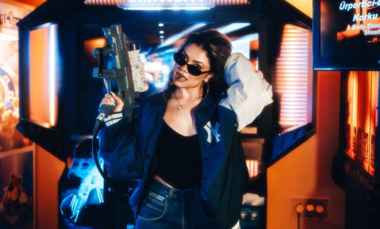 Fashionable young woman in an arcade holding a toy gun enjoying leisure time.