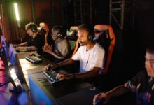 A group of young adults intensely focused on a competitive esports tournament indoors.