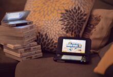 Two handheld gaming consoles on a sofa with game cartridges, creating a cozy game night mood.