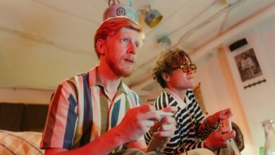 Two men playing video games with controllers and having fun in a cozy room.
