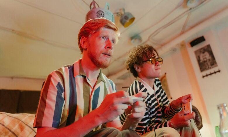Two men playing video games with controllers and having fun in a cozy room.