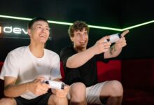 Two young men playing video games indoors, having fun and engaging with controllers.