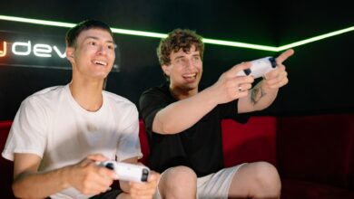 Two young men playing video games indoors, having fun and engaging with controllers.
