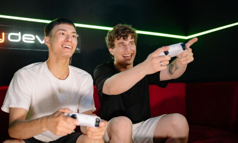 Two young men playing video games indoors, having fun and engaging with controllers.