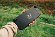 Person holding a Nintendo Switch in a natural outdoor setting, perfect for on-the-go gaming.