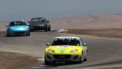 Mazda Miata sports cars racing on a sunny day at Buttonwillow Raceway, California.
