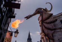 Stunning dragon sculpture breathing fire at a themed street in Orlando, Florida.