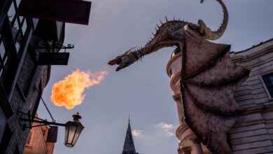Stunning dragon sculpture breathing fire at a themed street in Orlando, Florida.